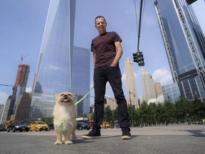 In this Wednesday, June 14, 2017 photo, Dion Leonard and his dog, Gobi, pose for a photo in New York. During a 155-mile race across the Gobi Desert, the dog sought out the the ultra-runner, who seems genuinely baffled by it all. He marvels at Gobi's ease crossing the Tian Shan mountain range and the distance she covered fending mostly for herself for food and water. (AP Photo/Patrick Sison)
