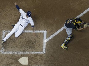 Milwaukee Brewers' Domingo Santana scores past Pittsburgh Pirates catcher Elias Diaz during the fifth inning of a baseball game Thursday, June 22, 2017, in Milwaukee. Santana scored from first on a double by Travis Shaw. (AP Photo/Morry Gash)