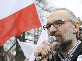 FILE - In this Dec. 19, 2015 file photo, Mateusz Kijowski, leader of the Committee for the Defense of Democracy, speaks at a demonstration in Warsaw, Poland. Poland's prosecutors said Wednesday June 28, 2017, they have charged the former leader of a massive anti-government movement with misappropriation of the movement's funds and false statements in its financial documents.  (AP Photo/Alik Keplicz, File)