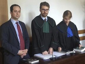 Matthew Tyrmand, left, a conservative American political activist with the group Project Veritas, stands in  a court along with his lawyers on the first day of a trial in Warsaw, Poland, on Wednesday  June 21, 2017. Tyrmand is suing a Polish journalist for defamation after the journalist in a 2016 article called him "Trump's man" and describing him as sympathetic to Russian President Vladimir Putin. The journalist, Tomasz Piatek, said his piece was a satirical response to critical remarks Tyrmand had made against his newspaper, Gazeta Wyborcza.  (AP Photo/Vanessa Gera)