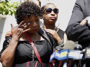 Eric Garner's sister Ellisha, center, consoles Garner's mother Gwen Carr, left, during a news conference after the family, attorneys representing the family and National Action Network director and founder the Rev. Al Sharpton met with Department of Justice, Wednesday, June 21, 2017, in New York. (AP Photo/Kathy Willens)