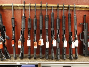 FILE - This June 27, 2013 file photo shows a rack of rifles at Firing-Line gun store in Aurora, Colo.  A new survey by the Pew Research Center shows Americans have grown more divided over gun issues. The survey of adults showed about half favor gun-control measures while about half support preserving gun rights. The results underscore the divide in the United States along political, racial, gender and geographic lines. (AP Photo/Ed Andrieski)