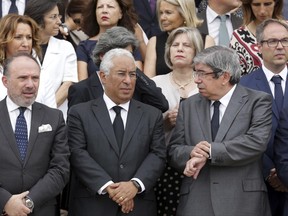FILE - In this file photo dated Wednesday, June 21 2017, Portuguese Prime Minister Antonio Costa, front center, and Parliament President Eduardo Ferro Rodrigues, right, stand with members of the government and lawmakers on the steps of the parliament building in Lisbon, waiting to observe a minute of silence in memory of the victims of a wildfire. Costa appeared to lose his patience with journalists' questions Wednesday June 28, 2017, amid criticism of how the blaze was handled and accusations about who might be to blame for recent wildfire deaths. (AP Photo/Armando Franca, FILE)