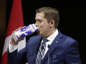Conservative Leader Andrew Scheer drinks milk on stage at the National Press Gallery Dinner in Gatineau, Quebec, Saturday June 3, 2017.