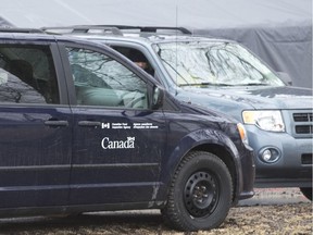 Canada Food Inspection Agency vehicles sit outside of a turkey farm on Highway 2, one of eight in Oxford County in a containment zone following a bird flu outbreak, west of Woodstock, Ontario on Wednesday April 8, 2015.