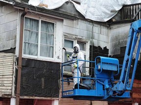 A work crew  carefully removes exterior tiles and disposes of asbestos from an old house on West 16th Ave. in Vancouver, BC., October 27, 2016.