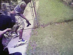 Screenshot from the trial of Milwaukee police officer Dominique Heaggan-Brown shows him chasing 23-year-old Sylville Smith. Smith appears to be holding his gun by the barrel to throw it over the fence. Prosecutors argue this means he wasn't an active threat.