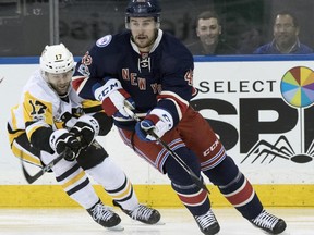FILE - In this March 31, 2017, file photo, New York Rangers defenseman Brendan Smith (42) and Pittsburgh Penguins right wing Bryan Rust (17) battle for the puck during the first period of an NHL hockey game, at Madison Square Garden in New York. The Rangers have agreed to terms on a new deal with defenseman Brendan Smith. General manager Jeff Gorton announced the deal Thursday, June 29, 2017. (AP Photo/Mary Altaffer, File)