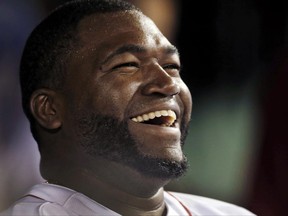 FILE - In this Sept. 4, 2013, file photo, Boston Red Sox designated hitter David Ortiz laughs with teammates in the dugout after hitting a double for his 2,000th career hit, in the sixth inning of a baseball game against the Detroit Tigers at Fenway Park in Boston. The Red Sox prepare to honor Ortiz, retiring the No. 34 worn by "Big Papi" when he led the once-cursed franchise to three World Series titles. The ceremony is Friday night, June 23, 2017.  (AP Photo/Elise Amendola, File)