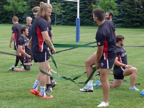 Canada rugby team forward Evan Olmstead (left) looks to untangle himself after stretching at practice in Markham, Ont., Tuesday, June 20, 2017. THE CANADIAN PRESS/Neil Davidson