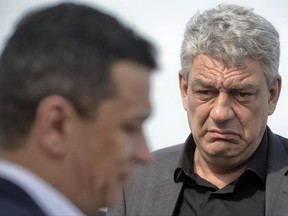 In this photo taken on May 12, 2017, economy minister Mihai Tudose, right, looks at former prime minister Sorin Grindeanu in Caravelle, Romania. The Social Democratic Party announced its choice for prime minister, lawmaker Mihai Tudose, 50-year-old economy minister in the previous government and an ally of Liviu Dragnea, the powerful leader of Romania's biggest political party. (AP Photo/Andreea Alexandru)