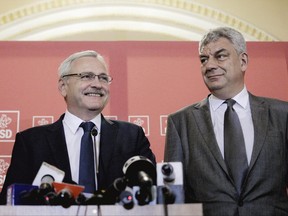 Prime Minister-designate Mihai Tudose, right, stands next to the head of the Social Democratic Party, Liviu Dragnea, during a press conference at the Romanian parliament, in Bucharest, Romania, Wednesday, June 28, 2017. Liviu Dragnea, the chairman of Romania's ruling Social Democratic Party has named the new leftist government, and many ministers are set to keep their jobs, despite being criticized for underperforming. (AP Photo/Andreea Alexandru)