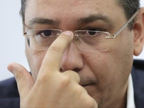 Romanian Government General Secretary and former Prime Minister, Victor Ponta, adjusts his glasses during an interview with the Associated Press in Bucharest, Romania, Monday, June 19, 2017.  Ponta's has called on lawmakers not to oust the prime minister in a no-confidence vote this week called by members of his own party.  (AP Photo/Vadim Ghirda)