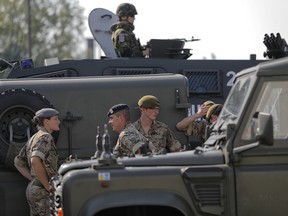 British troops stand near their vehicles after crossing the border from Bulgaria in Giurgiu, Romania, Thursday, June 1, 2017 to take part in the alliance's Noble Jump 2017 exercise.