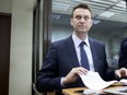 Alexei Navalny holds papers at a court room in Moscow, Russia, Tuesday, May 30, 2017