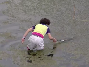 Li's mother rolled up her shorts and waded through the muddy water on the Golf National course Thursday as players watched.