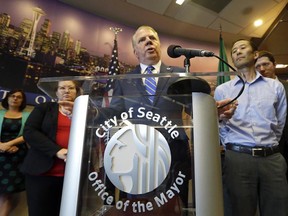 Seattle Mayor Ed Murray speaks at a news conference as his husband, Michael Shiosaki, right, stands nearby at City Hall Wednesday, June 14, 2017, in Seattle.