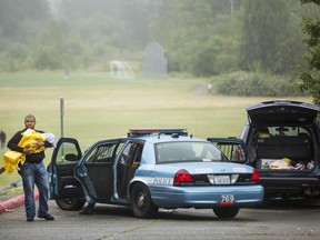 A Seattle Police officer cradles a child, with two more in the car, at the scene where police shot and killed a 30-year-old woman at the Brettler Family Place Apartments at Magnuson Park, Sunday June 18, 2017, in Seattle. According to police, two officers responded to a burglary call made by the woman, who they say brandished a knife at some point, and both officers shot her dead in her apartment. Children were home at the time and were physically unharmed. (Bettina Hansen/The Seattle Times via AP)