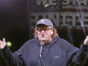 FILE - In this Thursday, Jan. 19, 2017, filmmaker Michael Moore speaks to thousands of people at an anti-Trump rally and protest in front of the Trump International Hotel in New York. Moore, who is making his Broadway debut this summer in a solo show, says he will donate $10,000 to New York City's Shakespeare in the Park after it lost funding from sponsors due to its controversial "Julius Caesar" production. (AP Photo/Kathy Willens, File)