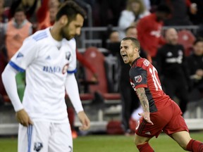 Toronto FC's Sebastian Giovinco runs past Montreal Impact's Matteo Mancosu as he celebrates his goal during Canadian Championship soccer action at BMO Field in Toronto on Tuesday night.