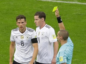 Germany's Leon Goretzka, left, is booked by referee Mark Geiger during the Confederations Cup, Group B soccer match between Australia and Germany, at the Fisht Stadium in Sochi, Russia, Monday, June 19, 2017. (AP Photo/Sergei Grits)