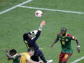 Cameroon goalkeeper Fabrice Ondoa, center, jumps to punch the ball away during the Confederations, Cup Group B soccer match between Cameroon and Australia, at the St.Petersburg stadium in St.Petersburg, Russia, Thursday, June 22, 2017. (AP Photo/Dmitri Lovetsky)