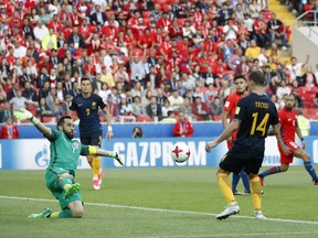 Australia's James Troisi, right, scores his side's first goal against Chile goalkeeper Claudio Bravo during the Confederations Cup, Group B soccer match between Chile and Australia, at the Spartak Stadium in Moscow, Sunday, June 25, 2017. (AP Photo/Pavel Golovkin)