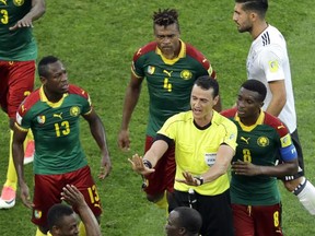 Referee Wilmar Roldan, center gestures as he is surrounded by Cameroon's players during the Confederations Cup, Group B soccer match between Germany and Cameroon, at the Fisht Stadium in Sochi, Russia, Sunday June 25, 2017. (AP Photo/Sergei Grits)