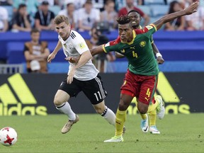 Germany's Timo Werner, left, and Cameroon's Adolphe Teikeu go for the ball during the Confederations Cup, Group B soccer match between Germany and Cameroon, at the Fisht Stadium in Sochi, Russia, Sunday, June 25, 2017. (AP Photo/Thanassis Stavrakis)