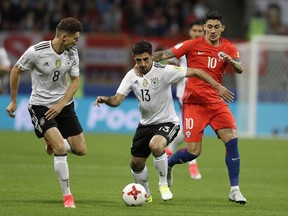 Germany's Leon Goretzka, left, looks on as Germany's Lars Stindl, center, and Chile's Pablo Hernandez challenge for the ball during the Confederations Cup, Group B soccer match between Germany and Chile, at the Kazan Arena, Russia, Thursday, June 22, 2017. (AP Photo/Thanassis Stavrakis)