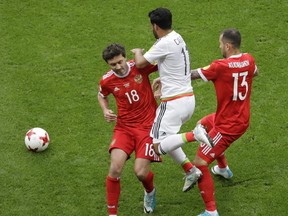 Mexico's Carlos Vela, center, is tackled by Russia's Yury Zhirkov, left, and Fedor Kudriashov, during the Confederations Cup, Group A soccer match between Mexico and Russia, at the Kazan Arena, Russia, Saturday, June 24, 2017. (AP Photo/Sergei Grits)