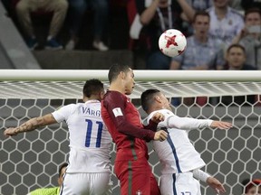 Portugal's Cristiano Ronaldo, center, jumps for the ball with Chile's Eduardo Vargas and Gary Medel, right, during the Confederations Cup, semifinal soccer match between Portugal and Chile, at the Kazan Arena, Russia, Wednesday, June 28, 2017. (AP Photo/Ivan Sekretarev)