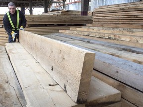 A worker tidies up the wood pile at a lumber yard Tuesday, April 25, 2017 in Montreal. Canada's softwood lumber industry faces average duties of about 27 per cent after the U.S. Department of Commerce slapped it with an additional 6.87 per cent in preliminary average anti-dumping tariffs. The two governments may be close to finally wrapping the trade disagreement.