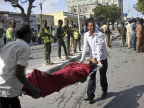 Somalis carry away the body of a civilian who was killed in a suicide car bomb attack on a police station in Mogadishu, Somalia Thursday, June 22, 2017. A number of people are dead and several others wounded in the blast in Somalia's capital, police said Thursday, adding that the bomber was trying to drive into the police station's gate but detonated against the wall instead. (AP Photo/Farah Abdi Warsameh)