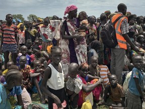 In this photo taken Saturday, June 17, 2017, men, women and children line up to be registered with the World Food Programme (WFP) for food distribution in Old Fangak, in Jonglei state, one of the worst affected areas for food insecurity according to a food security report, in South Sudan. South Sudan no longer has areas in famine, but almost 2 million people are on the brink of starvation and an estimated 6 million people - half the population - will face extreme food insecurity between June and July, according to reports by the government and the United Nations released Wednesday, June 21, 2017. (AP Photo/Sam Mednick)