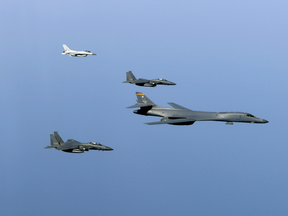 A U.S. B-1B bomber (R) conducts a training exercise with Korean fighters.