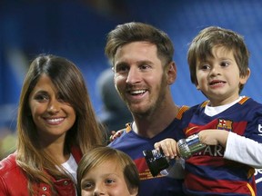FILE - This is a Sunday, May 22, 2016  file photo of Barcelona's Lionel Messi, carrying his son, poses for a photo with his girlfriend Antonella Roccuzzo as they celebrate after winning the final of the Copa del Rey soccer match between FC Barcelona and Sevilla FC at the Vicente Calderon stadium in Madrid. Messi who will be the center of the attentions on Friday June 30, 2017  in his hometown of Rosario, Argentina,where he will be marrying 29-year-old Antonella Roccuzzo, his childhood friend and mother of his two children. Child in foreground is unidentified.  (AP Photo/Francisco Seco/ File)