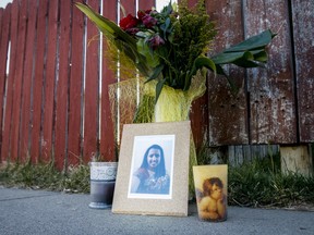 A picture of Sanjula Devi sits beneath flowers outside her home in the 6400 block of Penbrooke Dr SE in Calgary, Alta., on Wednesday, May 7, 2014. Sanjula Devi and Fahmida Velji-Visram were stabbed to death three days earlier, allegedly by Devi's estranged husband.