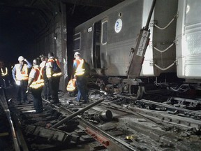 In this photo provided by the Transport Workers Union, Local 100, workers from the New York Metropolitan Transportation Authority examine damaged train tracks, at the scene of a subway derailment, Tuesday, June 27, 2017, in New York.