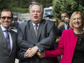 Greek Foreign Minister, Nikos Kotzias, center, shakes hands with UN Secretary-General's Special Adviser on Cyprus, Espen Barth Eide, left, and Elizabeth Spehar, UN Secretary-General's Special Representative and Head of the United Nations Peacekeeping Force in Cyprus, right, upon his arrival at the beginning of a new round of the conference on Cyprus under the auspices of the United Nations, in Crans-Montana, Switzerland, Wednesday, June 28, 2017.  (Jean-Christophe Bott/Keystone via AP)