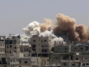 A screengrab shows smoke rising over buildings that were hit by Syrian government forces bombardment, in Daraa city, southern Syria