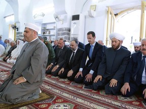 In this photo released by the Syrian official news agency SANA, Syrian President Bashar Assad, third right, prays on the first day of Eid al-Fitr, that marks the end of the Muslim holy month of Ramadan, at the Nouri Mosque in Hama, Syria, Sunday, June 25, 2017. (SANA via AP)