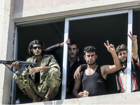 Free Syrian Army fighters give the victory sign, in Jarablus, Syria.