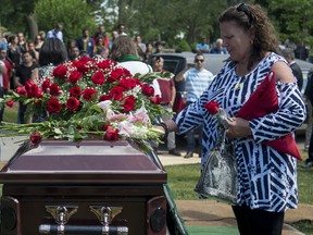 Tina Martino places her hand on the casket of her son Nazzareno Tassone in Niagara Falls, Ontario, June 21, 2017.
