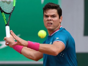 Milos Raonic returns the ball to Pablo Carreno Busta during their French Open match on June 4.