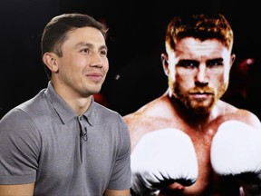 IBF and WBC world middleweight boxing champion Gennady Golovkin, left, poses beside a giant photograph of his upcoming opponent, six-time title holder Saul "Canelo" Alvarez of Mexico, during an interview ahead of their Sept. 16th Las Vegas superfight, Tuesday, June 20, 2017, at The Associated Press in New York. (AP Photo/Kathy Willens)
