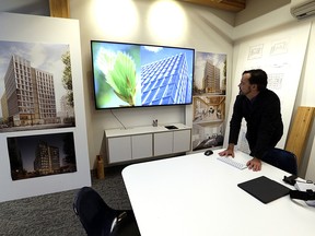 In this Nov. 15, 2016, file photo, Lever Architecture founder Thomas Robinson looks over artist renderings in Portland, Ore., of a 12-story all-wood building that his firm is working on to be built in Portland's trendy Pearl District.