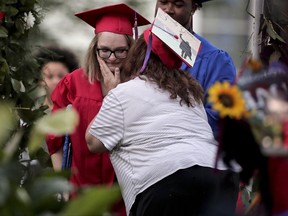 Dunellen High School senior Destiny Lightfoot, left, receives a kiss on the cheek from Elaine Williams, the mother of classmate Jessica Williams, shortly before receiving her diploma during graduation ceremonies Wednesday, June 21, 2017, in Dunellen, N.J. Both Lightfoot and Jessica were injured in Times Square when Richard Rojas drove through a crowd of pedestrians last month. (AP Photo/Julie Jacobson)
