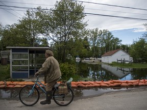 A man rides his bike past a row of sandbags keeping floodwaters at bay on the Toronto Islands on June 1, 2017.