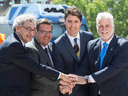 Caisse de Dépôt president Michael Sabia, Montreal mayor Denis Coderre, Prime Minister Justin Trudeau and Quebec Premier Philippe Couillard, left to right, join hands after announcing a $1.28-billion federal commitment toward a major Montreal rail project on Thursday, June 15, 2017 in Montreal.